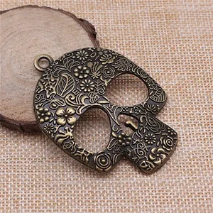 Vintage Bronze Totenkopf Anhänger mit filigranem Blumenmuster für DIY Schmuck.