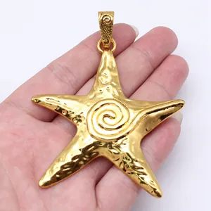 Large gold-plated starfish pendant with a hammered texture and central spiral motif