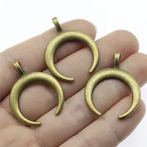 Antike Bronze Horn Halbmond Anhänger für DIY Schmuckherstellung in der Hand gezeigt