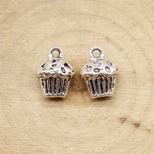 Antik silberne 3D-Cupcake-Anhänger für die Schmuckherstellung auf Naturholzoberfläche