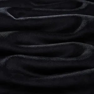 Detailed close-up of soft black velvet fabric for men's winter plush sweatpants texture