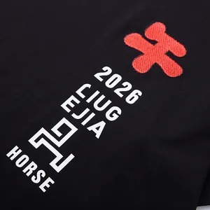 Κοντινό πλάνο μαύρου βαμβακερού t-shirt με κόκκινο κέντημα και λευκά τυπωμένα γραφικά