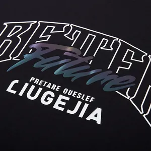Detail view of the iridescent reflective letter print on a stylish oversized black cotton T-shirt