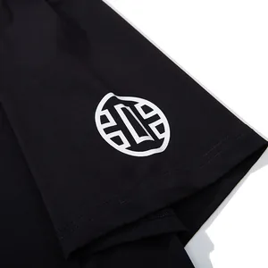 Detailed close-up of a black oversized T-shirt sleeve featuring a white circular graphic print