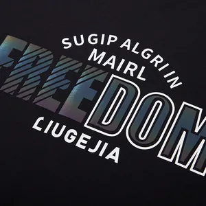 Close-up of black T-shirt with holographic FREEDOM letter print and reflective finish.