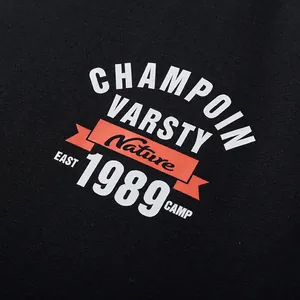 Close-up of black oversized T-shirt with white and red varsity graphic print detail.