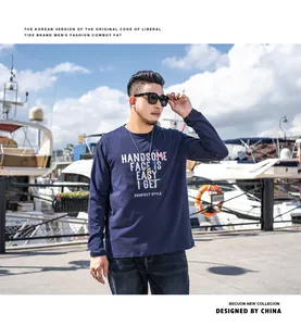 Mann in marineblauem Oversize-Langarm-T-Shirt mit Grafikdruck in einem Yachthafen