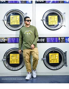 Modell trägt armee grünes Langarm-T-Shirt mit Grafikdruck und Cargohose