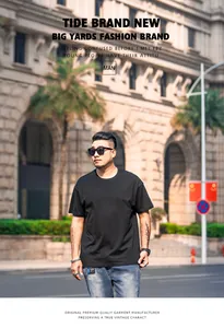 Man wearing black plus size loose drop shoulder plain t-shirt in urban street setting