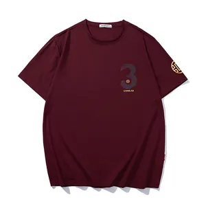 Stylish oversized burgundy men's T-shirt featuring gold and reflective graphic prints.