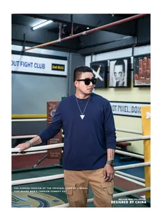Professional lifestyle shot of men's plus size navy blue long sleeve crew neck T-shirt.