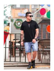 Fotografía street style de un modelo masculino con camiseta gráfica negra y vaqueros