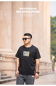 Plus size men's street style black t-shirt worn by model in urban outdoor setting