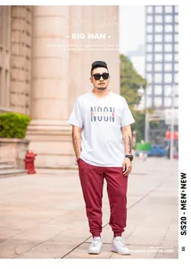 Full view of plus size men's joggers with white graphic t-shirt on a model