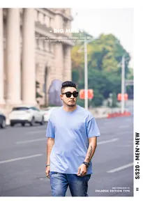Street style view of a men's light blue oversized short sleeve T-shirt in plus size.