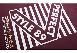 Detailansicht des weißen geometrischen STYLE 89 Buchstabendrucks auf einem weinroten T-Shirt
