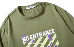 Detailaufnahme eines armee-grünen T-Shirts mit auffälligem weißem Buchstaben-Print