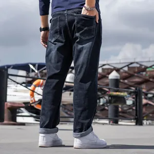 Men's loose black straight-leg jeans for business casual wear, rear view outdoor port
