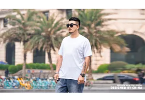 Men's loose drop shoulder short sleeve white T-shirt shown in outdoor urban setting
