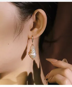 Primer plano de pendientes de perlas barrocas hechos a mano con elegante alambre enrollado.