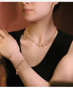 Dettaglio di un set di gioielli con perle e vetro indossato da una modella.