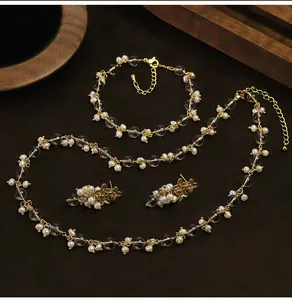 Dettaglio del set di gioielli con perle naturali e vetro su sfondo in legno pregiato.