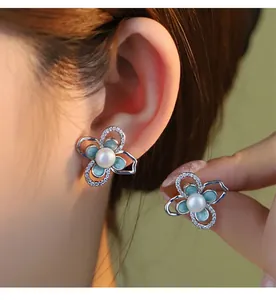 Primo piano di orecchini a lobo a forma di fiore in argento s925 con perla e cristalli