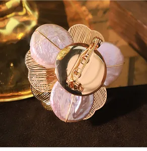Detailed back view of an elegant baroque pearl flower brooch with high quality gold finish