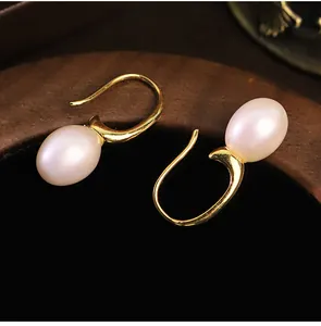 Primo piano dettagliato di eleganti orecchini in perla naturale d'acqua dolce con ganci oro