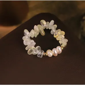 Detail showing natural pearl and prehnite stone chip ring on dark leather background