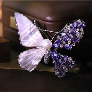 Close-up of butterfly brooch with purple zircon and iridescent pearl shell wings