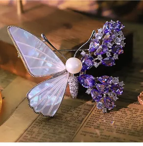 Exquisite macro detail of a vintage butterfly brooch with purple zircons and natural shell.