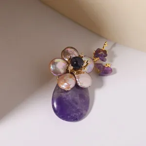 Detail view of purple agate and freshwater pearl flower brooch with gold accents.