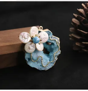 Close-up of baroque freshwater pearl flower brooch with blue crystal druzy detail