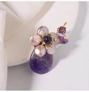 Close-up of elegant flower brooch with purple agate and natural freshwater pearls