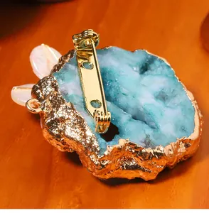 Detail showing the back mechanism of a baroque druzy stone brooch with gold plating.