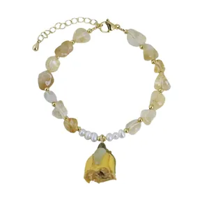 Pulsera artesanal de perlas y cristales con colgante de flor eterna amarilla sobre fondo blanco