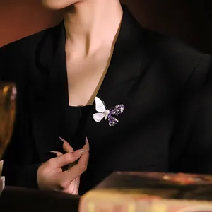 Elegant vintage butterfly brooch with pearl shell and purple zircons on a black blazer