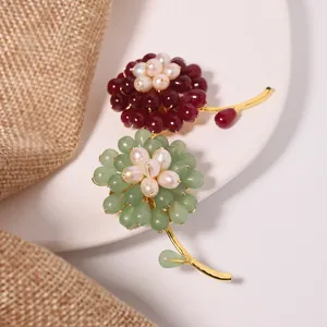 Elegant handmade aventurine and freshwater pearl sunflower brooches on a white decorative plate