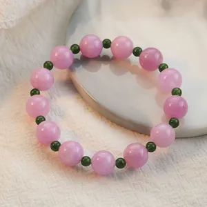Eleganter handgefertigter Kunzit und grüner Kristall Perlenarmband auf weißem Teller