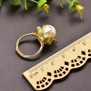 Detailed macro view of handmade gold wire wrapped ring with a large white Baroque pearl.
