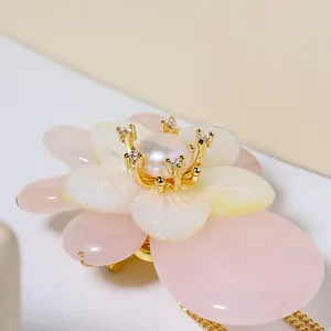 Detailaufnahme einer Brosche aus natürlicher Muschel in Pink mit Perle und Gold