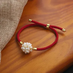 Handcrafted red string bracelet with an elegant pearl flower ball and gold accents.