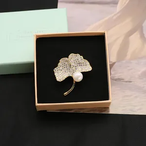 Elegant gold ginkgo leaf brooch with sparkling crystals and a freshwater pearl
