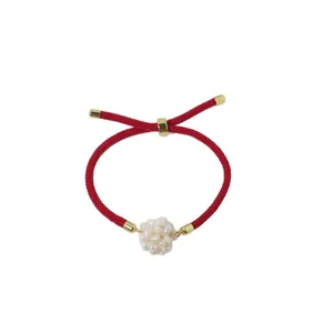 Red rope bracelet featuring a white freshwater pearl flower ball and gold accents