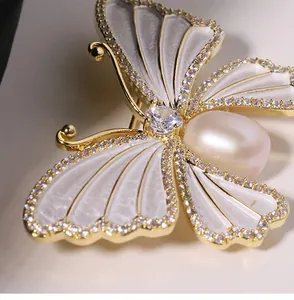 Macro detail van luxe parelmoer vlinderbroche met echte natuurlijke zoetwaterparel