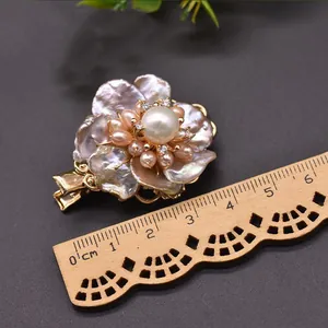 Primo piano di un fermaglio per capelli a fiore di perle con righello per riferimento.