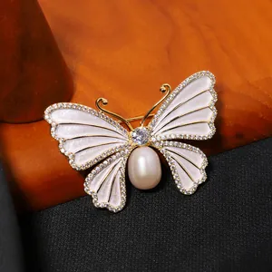 Elegante vlinderbroche met natuurlijke zoetwaterparel en kristallen