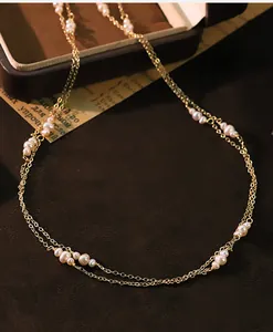Gedetailleerd aanzicht van een minimalistische dubbelstrengs natuurlijke parelketting goud