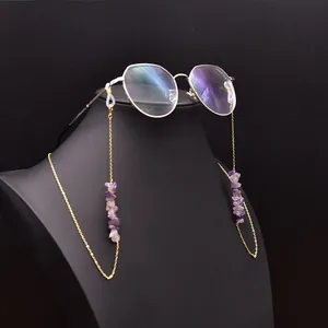 Detail view of a golden eyeglass chain with symmetrical purple amethyst stones on glasses.